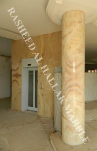 granite 7.3 meters  and onyx bookmatcth curved segmented column at khawaneej – dubai